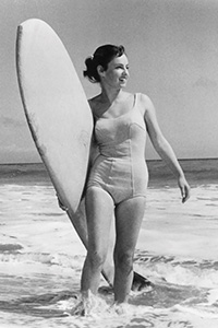 Bikini Geschichte: Kathy Kohner Zuckerman alias „Gidget“ mit Surfbrett im Jahr 1957. Ihr Surfer-Leben wurde nicht nur in einem Roman ihres Vaters festgehalten, sondern wurde in den darauffolgenden Jahrzehnten auch in verschiedenen Serien dargestellt.